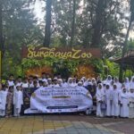 Anak yatim membentangkan spanduk kegiatan “Berbagi Kebahagiaan & Silaturahmi Bersama di kawasan Surabaya Zoo pada Rabu (4/3/2026).