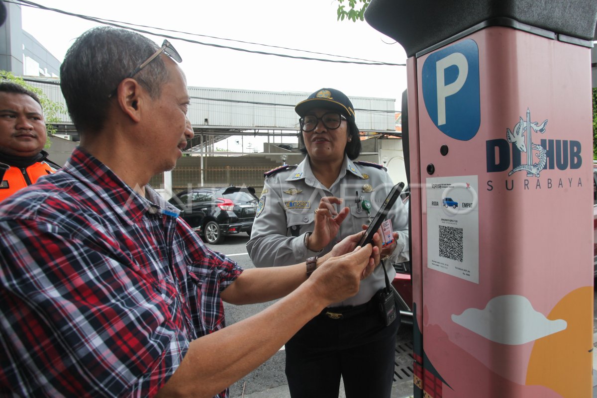 Petugas memantau pembayaran parkir nontunai oleh masyarakat di Kota Surabaya.